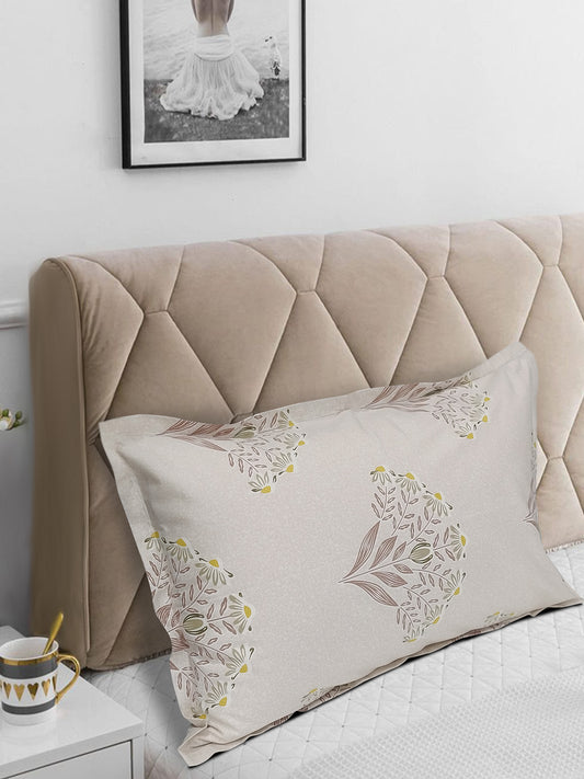 Decorative pillow with floral patterns on a bed with a tufted headboard.