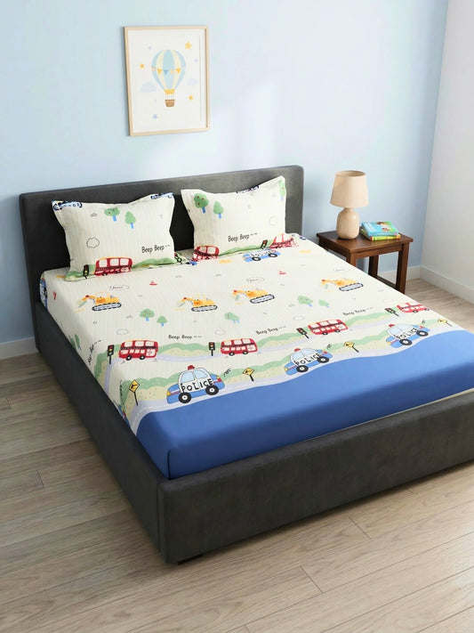Children's king size bed with cartoon-themed bedsheet in a room with a lamp and picture on the wall.